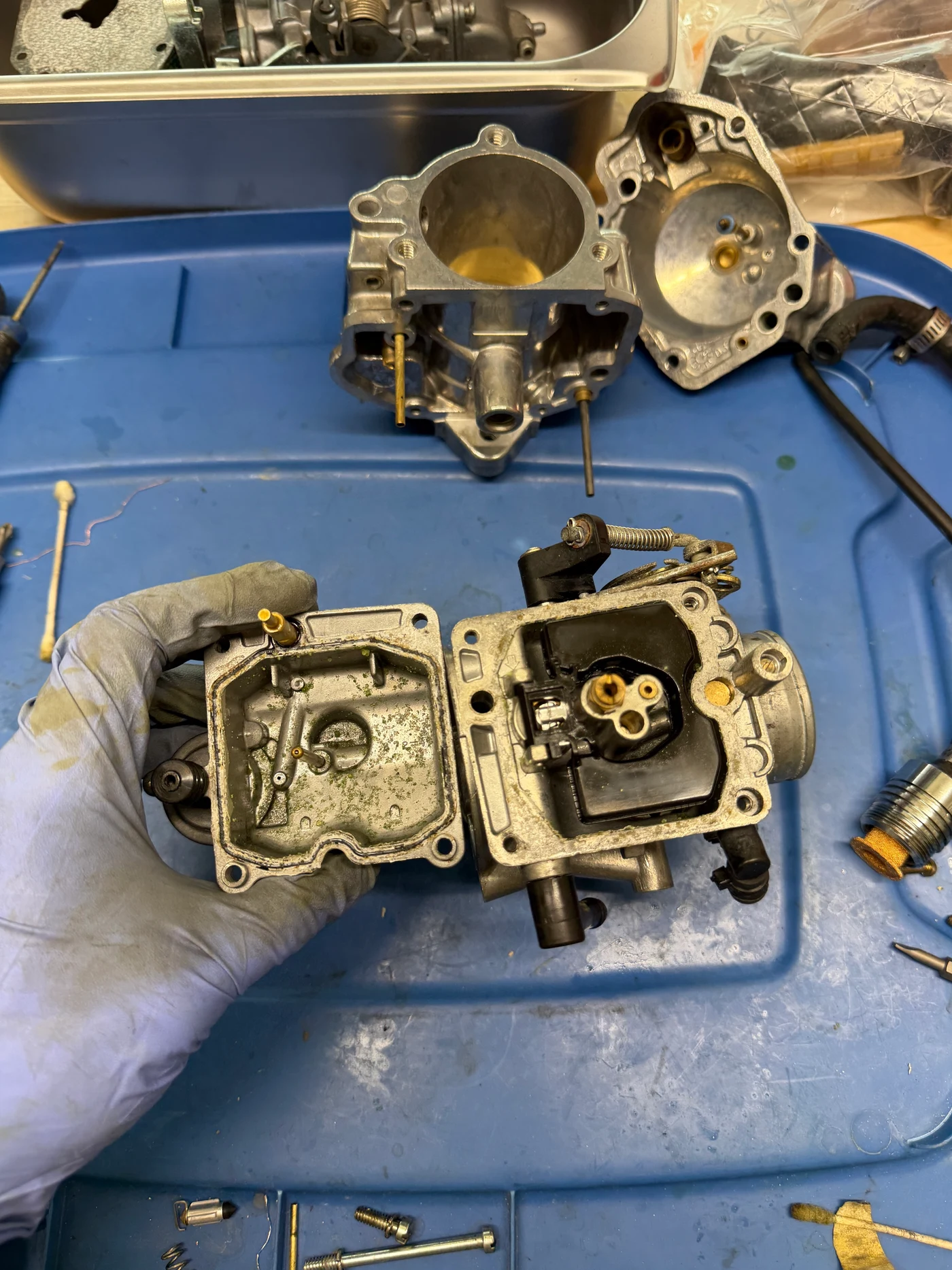 Debris and residue inside a disassembled motorcycle carburetor