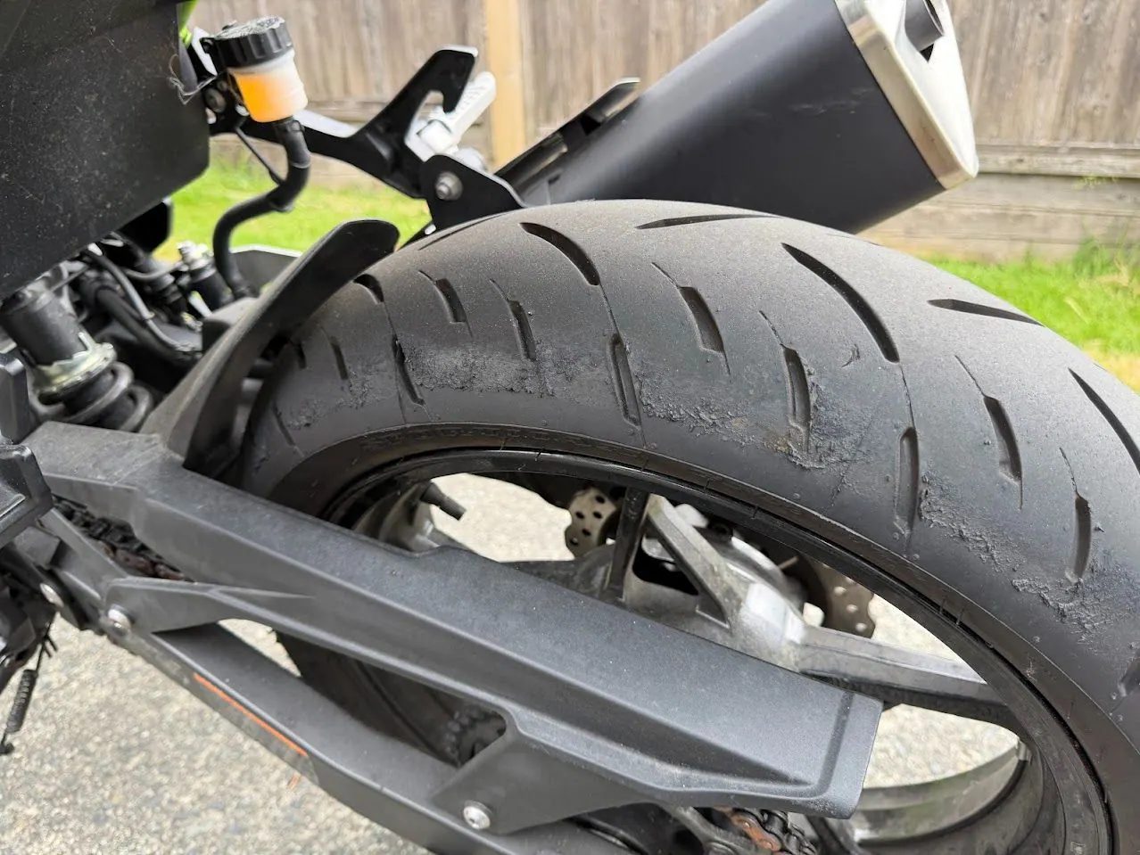 Close-up inspection of a worn motorcycle rear tire before a used-bike purchase